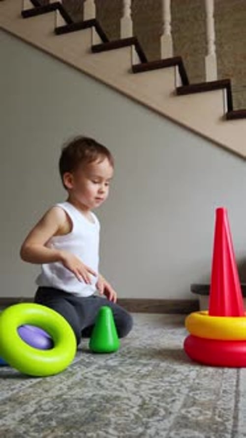 Boy Plays With Stacking Rings at Home