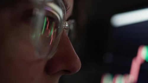 Person Analyzing Stock Market Charts with Reflections