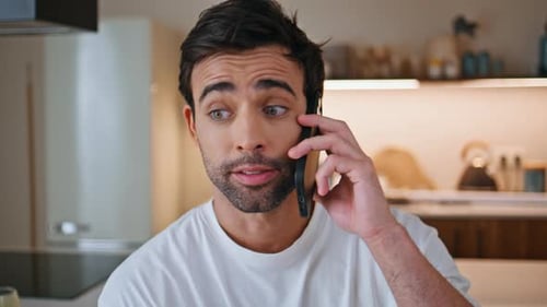 Smiling Man Talking on Cell Phone in Kitchen