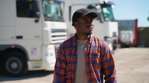 A Truck Driver Walks Across a Parking Lot to His Truck