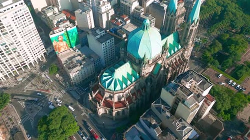 Vista aérea de una catedral con cúpulas verdes rodeadas de edificios urbanos y zonas verdes en São Paulo