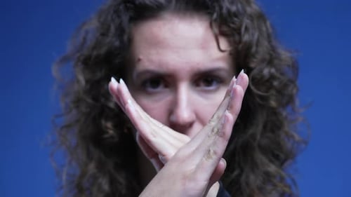Woman reacting with rejection by crossing hands in refusal. Person pushing away offer