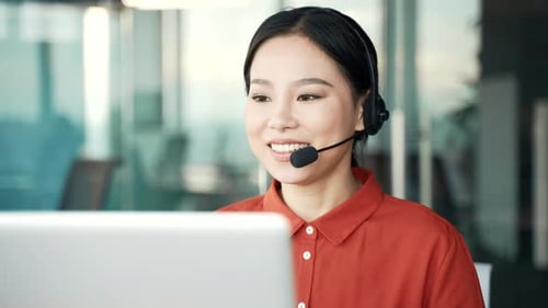 Smiling Woman with Headset Working at Computer