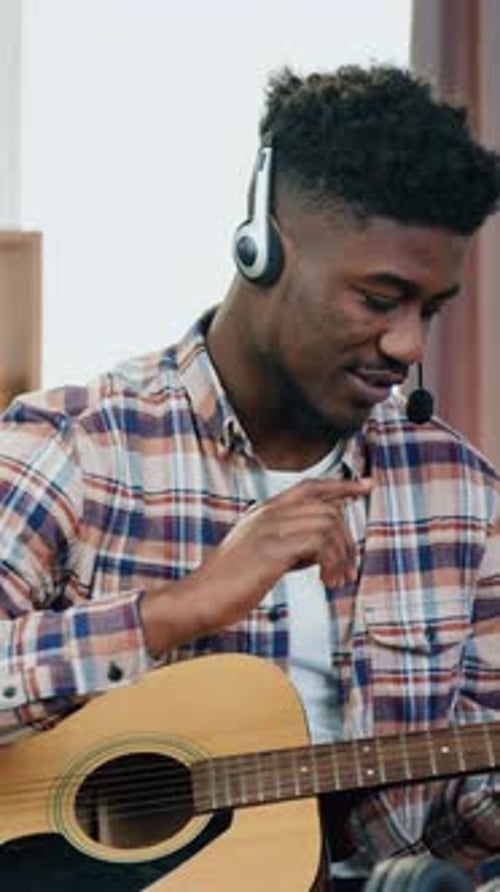 Man Playing Guitar and Teaching Music Online