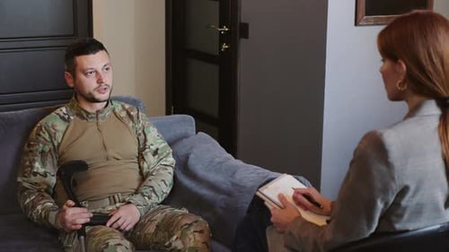 Soldier with Crutch Talking with Therapist in Office
