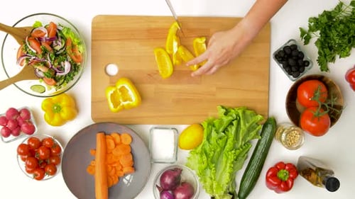 Overhead shot of person chopping vegetables on cutting board