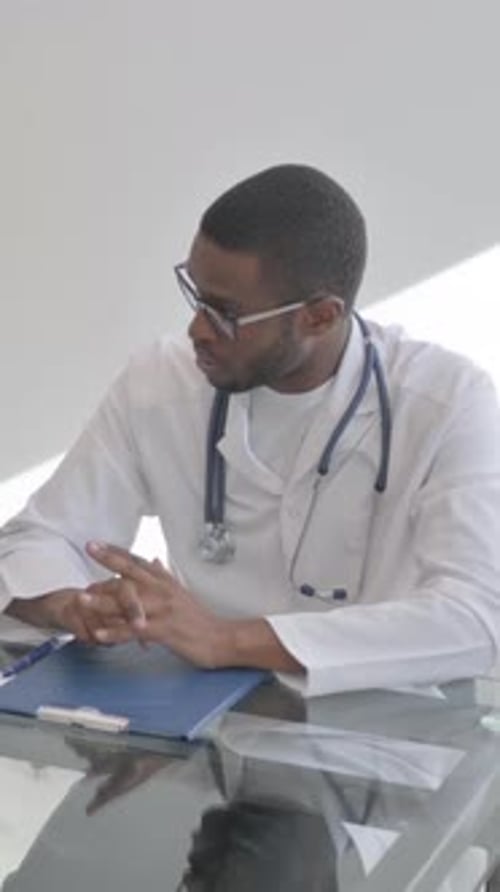Doctor Discussing Treatment with Young Man in Clinic, vertical video