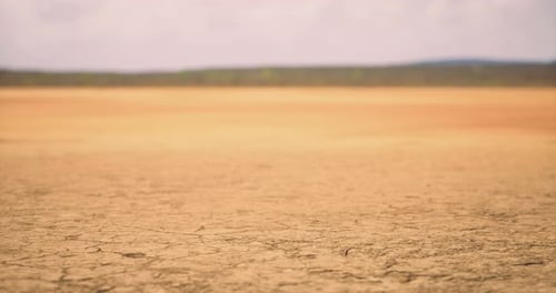 Terre fissurée sèche sous un ciel nuageux dans un paysage isolé pendant la journée