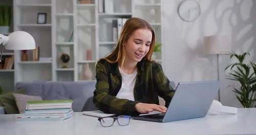 Smiling Woman Using Laptop Computer for Work in Home Office. Business Lady is Enjoying Success