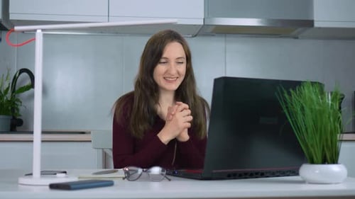 Woman Talking to Laptop at Desk