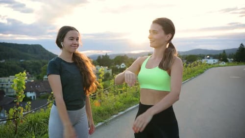 Portrait of Young Beautiful Caucasian Women Standing at the Street After Training and Giving Five to