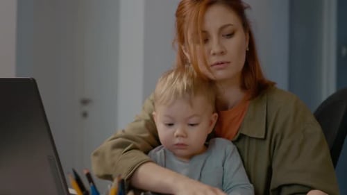 Young mother manages work and baby in home office environment