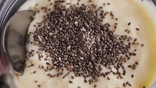 Spoon Stirring Chia Seeds in Bowl of Yogurt