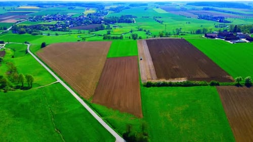 Aerial View of Diverse Agricultural Fields with Varied Crop Growth and Scenic Countryside