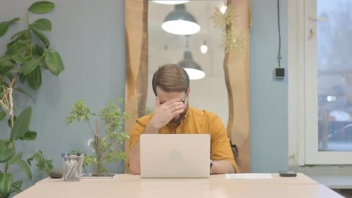 Stressed Man Working at Computer in Office