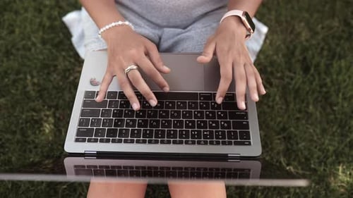Nahaufnahme einer jungen Frau, die auf einem Laptop tippt