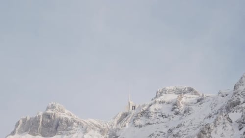 Swiss Mountain Saentis in the alps with fresh snow and fog. Beautiful snowy mountains and trees. Wea