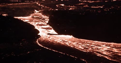 River of hot viscous lava flowing on earth surface at night, Iceland