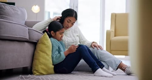 Child and Adult Using Phone Together at Home