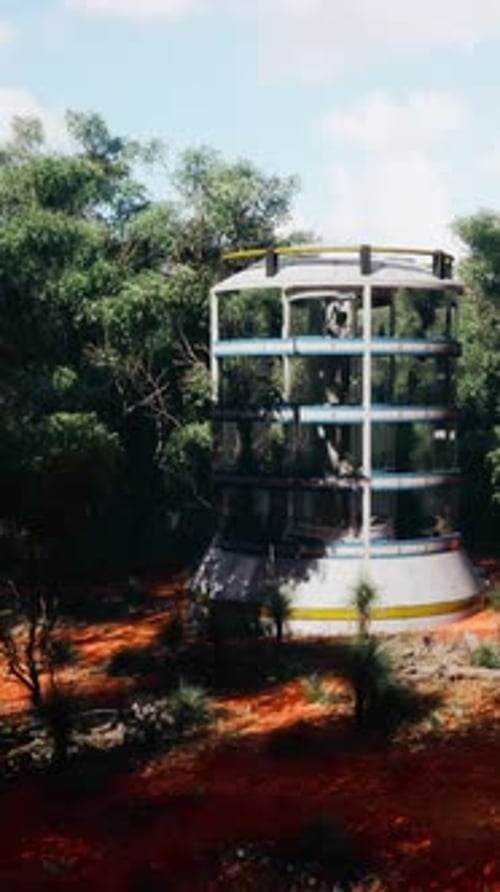 A Futuristic Glass Greenhouse Tower Amidst a Lush Forest Landscape