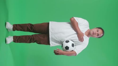 Full Body Of Asian Man With A Ball Singing National Anthem While Cheering Soccer On Green Screen