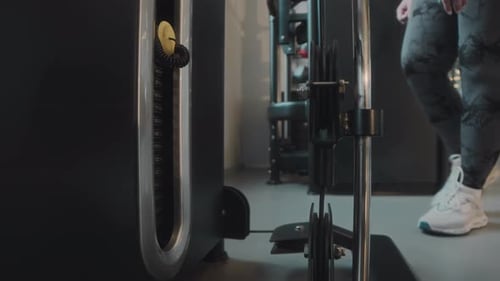 Plus Size Woman Adding Weight Bars on Gym Machine