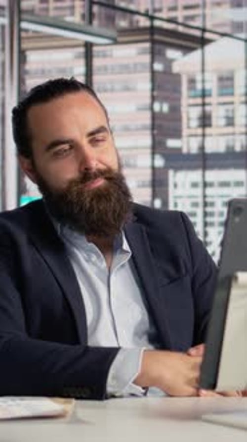 Man with Beard Video Conferencing in Office Building