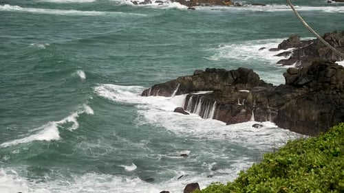 Ocean Waves Crashing Against Rugged Coastal Rocks on a Stormy Day. slow motion