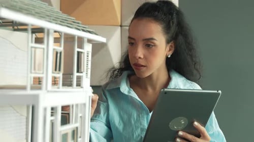 Un
architecte hispanique analyse la construction d'un bâtiment à l'aide d'une tablette. Manipulateur.