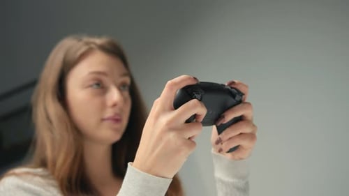 Close-up: A woman plays a console with a joystick or gamepad. Girl playing computer games
