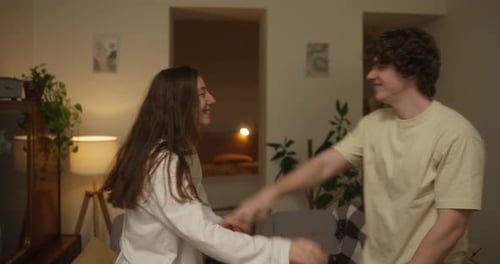 Happy Young Couple Dancing and Laughing at Home