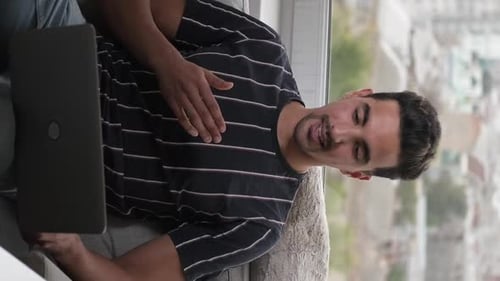 Smiling Man Using Laptop for Video Call Indoors