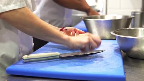 Hand-held shot of chefs cutting up and preparing large potatoes to cook