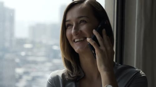 Happy woman talking on the cell phone at home