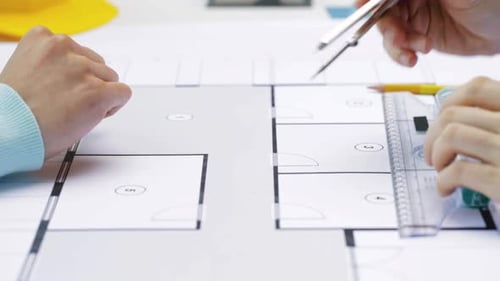 Architects Reviewing Blueprint with Compass and Ruler