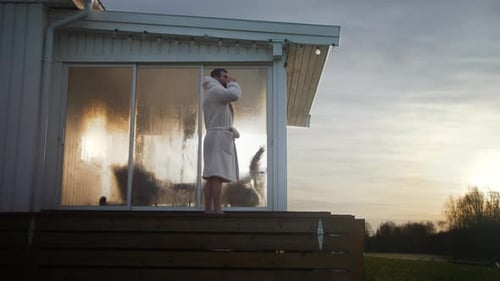 Man Relaxing With Coffee on Cabin Porch