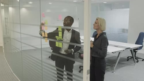 Team Brainstorming Ideas Using Sticky Notes in Office