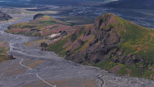 Aerial View of Braided River in Icelandic Valley with Rugged Terrain