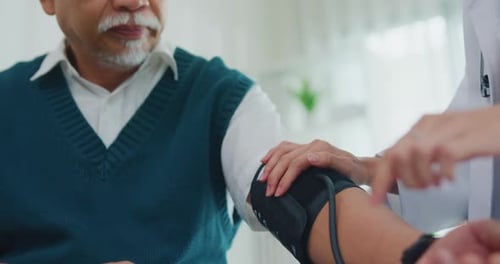 Young Asia female doctor with old man patient using blood pressure consultation in health clinic.