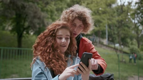 Smiling Young Beautiful Couple Sit in City Having Fun Together Laughing Use Phone Love Smile Street