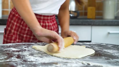 Woman Rolling Dough in Bright Kitchen