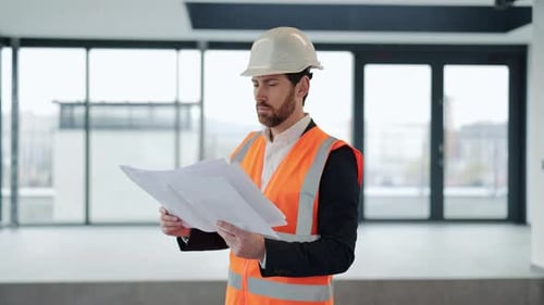 Arquiteto profissional analisa plantas em um edifício moderno