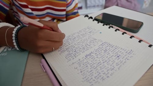 Close-up Hand Writing in Notebook at Table