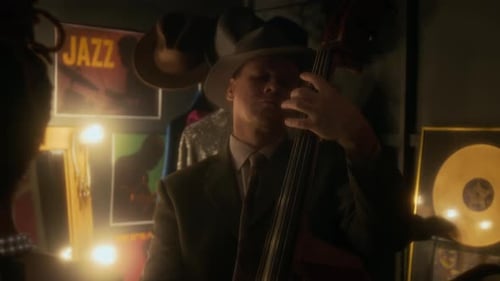 Man Plays Jazz Double Bass in Dimly Lit Room