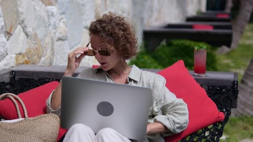 Woman Working on Laptop in Tropical Outdoor Setting
