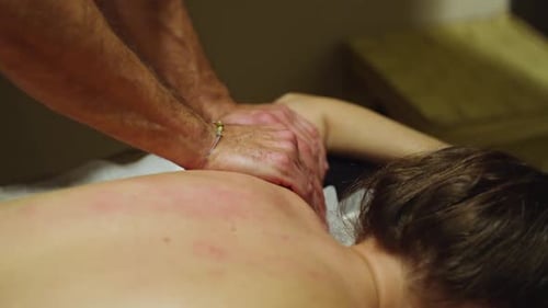 A Massage Therapist is Working on the Client's Shoulder - Close Up