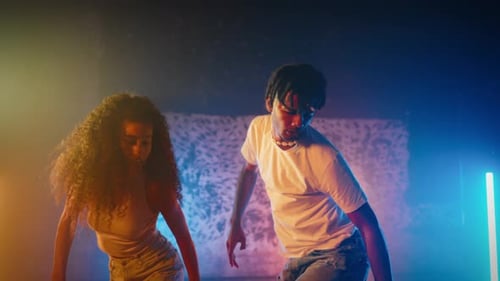 Energetic Young Dancers Performing in Studio with Colorful Lights