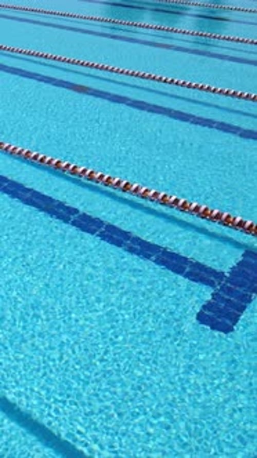 Leere Außenschwimmbadwege mit klarem blauem Wasser, Ansicht von oben.