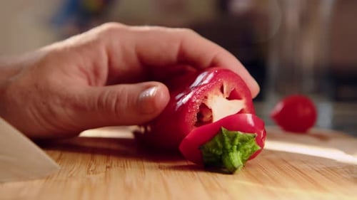 Hand Slices a Red Pepper on Cutting Board