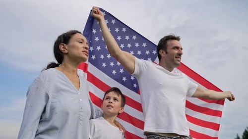 Mixed Race Family Happily Poses with American Flag
